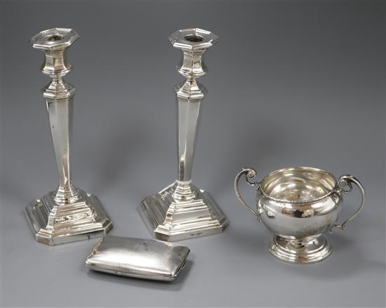 A pair of silver candlesticks, a silver two handled bowl and a late Victorian silver double hinged cigarette case.